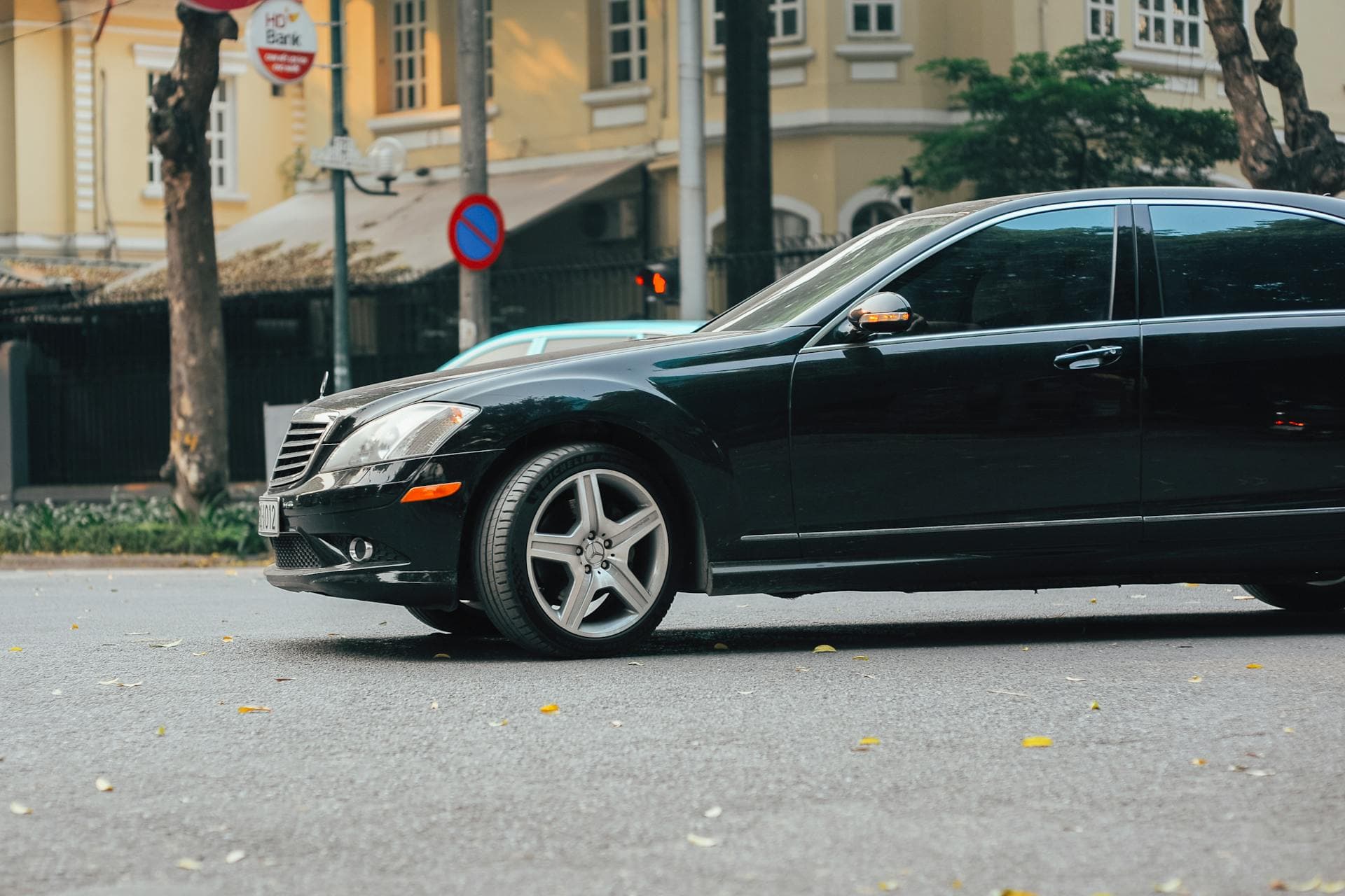 Black luxury sedan parked on urban street near heritage building, Adelaide 500 road closure pickup logistics