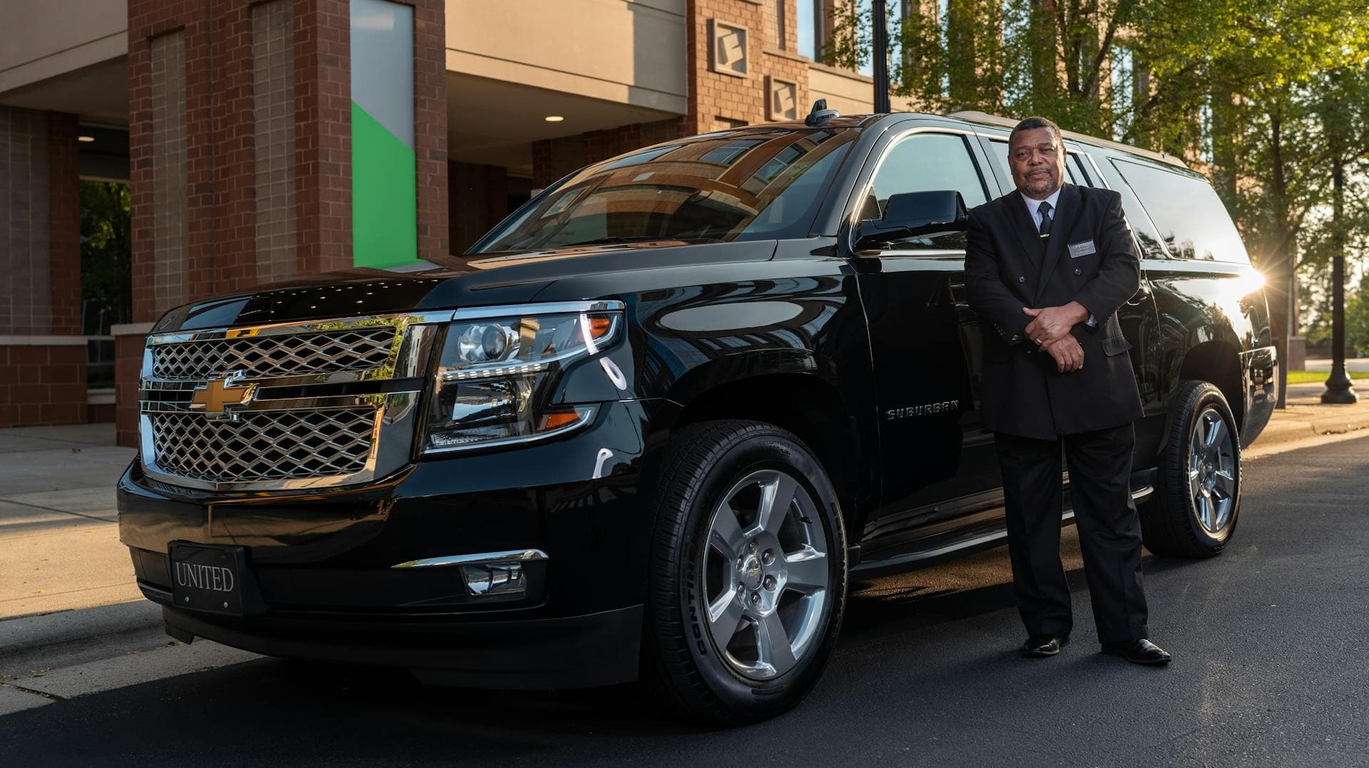 Chauffeur in professional attire beside luxury SUV, Adelaide owner-operated chauffeur service