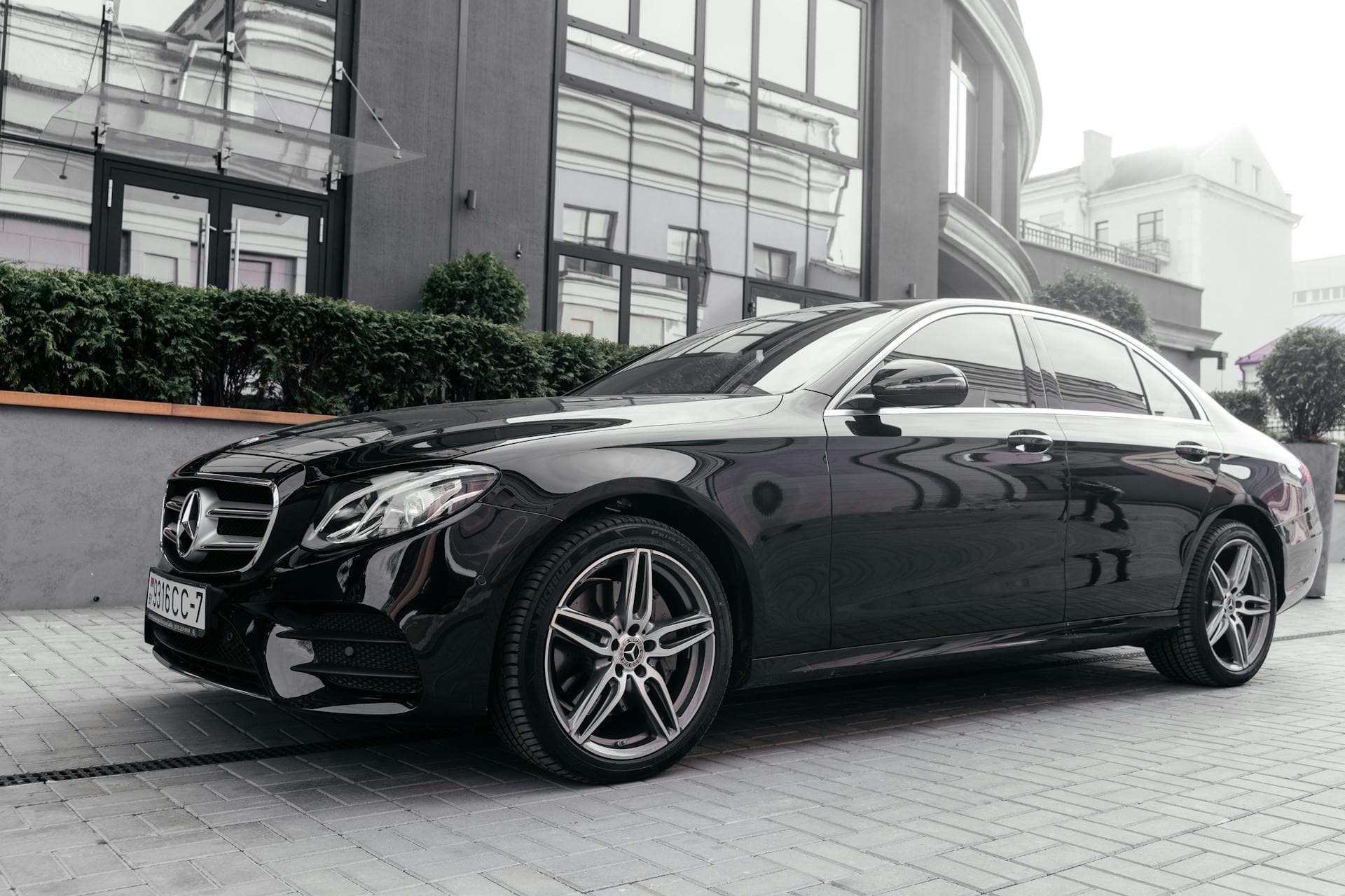 Black Mercedes E-Class sedan outside contemporary office building, Adelaide corporate chauffeur service