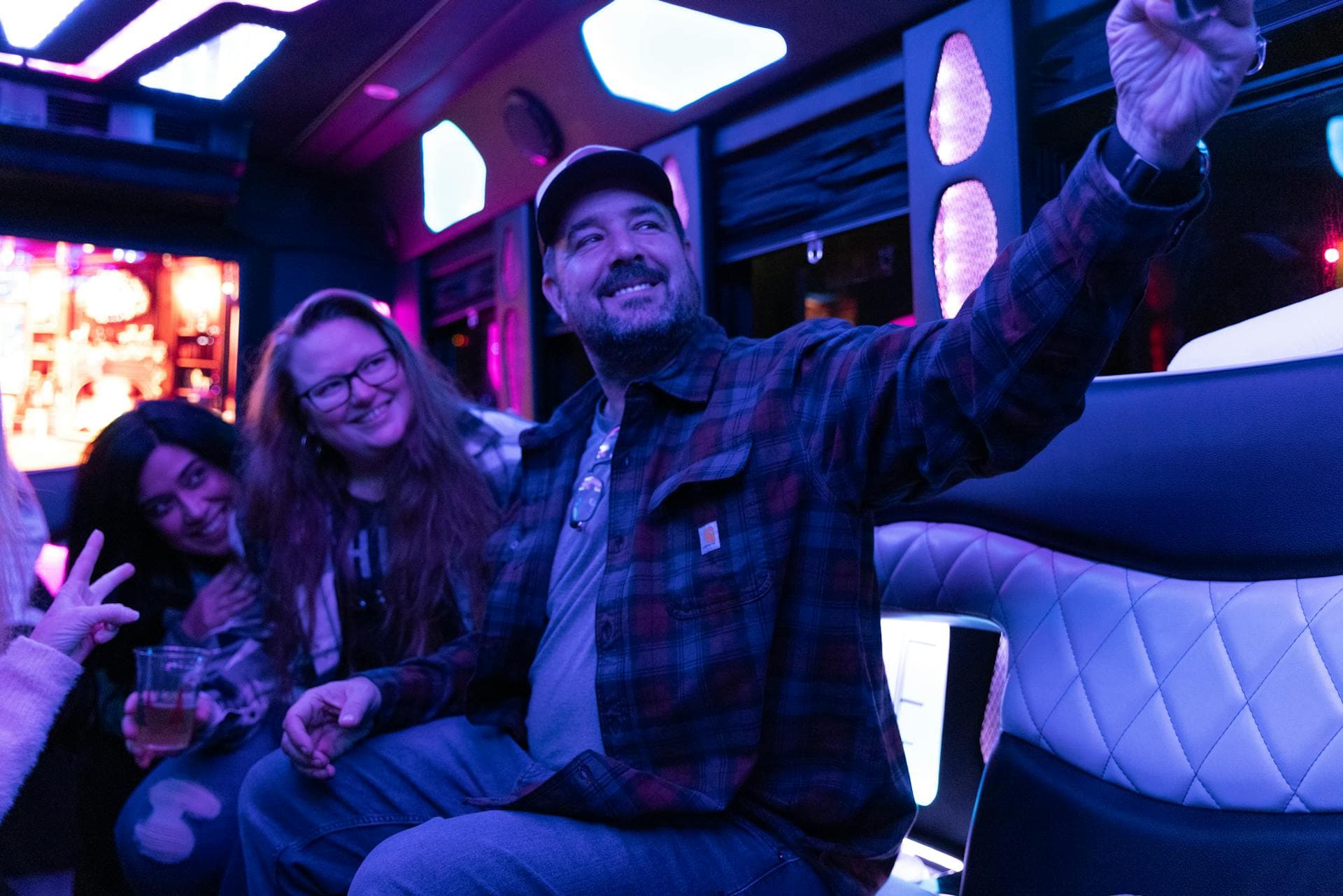 Friends inside party bus with LED lighting on a night out, Adelaide hens and bucks transport