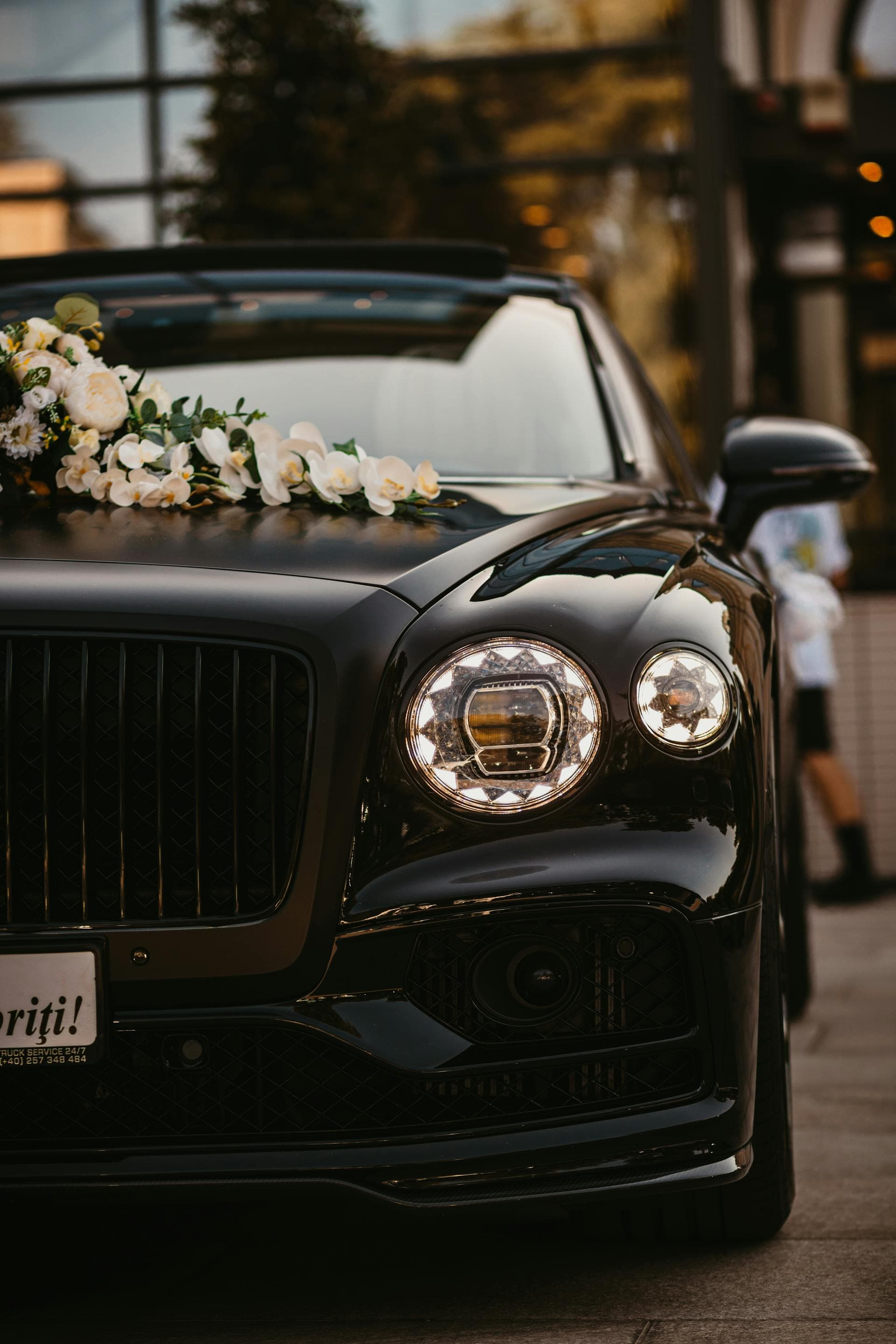 Black luxury wedding car with white floral arrangement on bonnet, Adelaide bridal transport service